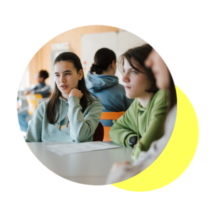 Jugendliche Mädchen sitzen an einem Tisch in der Schule und sprechen miteinander